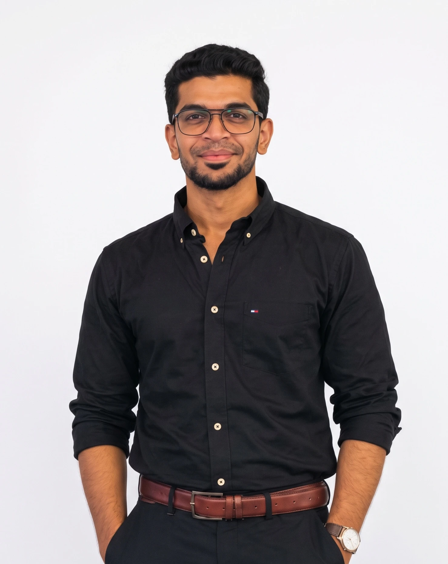 Mohammed Ashfaq Ahmed in a black shirt, smiling, against a plain white backdrop